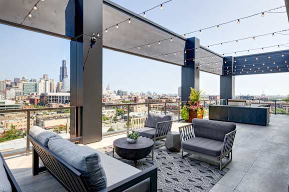 A rooftop patio with a view of the city skyline. at The Mason Apartments, Illinois, 60607