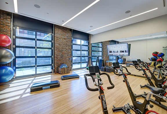 A gym with a brick wall and wooden floors. at The Mason Apartments, Chicago, Illinois