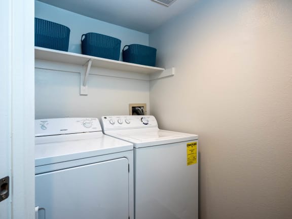 the washer and dryer in the laundry room of a home with blue walls