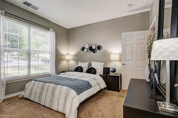 Staged bedroom with nightstands and wall decor at Wyndchase Aspen Grove Apartments, Tennessee
