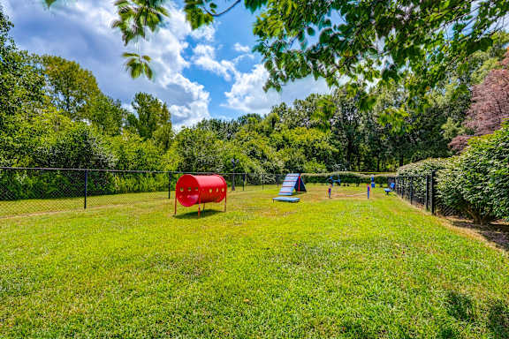 Outdoor pet play area with tunnel and agility equipment at Wyndchase Aspen Grove Apartments, Franklin, 37067