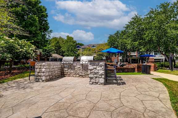 Outdoor grilling area with built in stone barbecue stations at Wyndchase Aspen Grove Apartments, Franklin, TN 37067