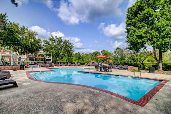 Swimming pool with deck chairs and surrounding trees at Wyndchase Aspen Grove Apartments, Franklin, Tennessee