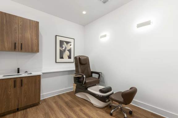 A brown massage chair in a room with wooden floors and white walls.