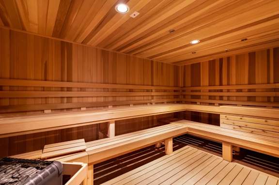 A wooden sauna with benches and a black towel.