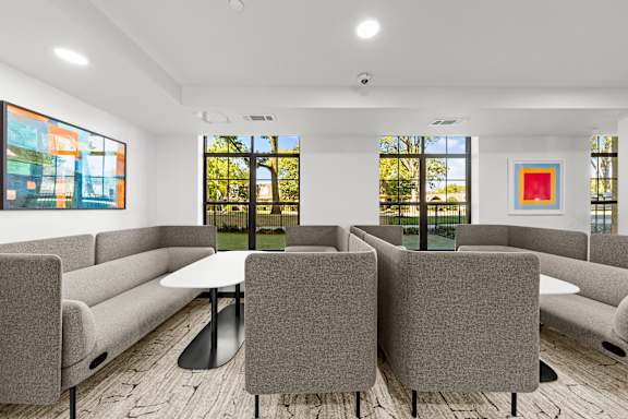A conference room with a table surrounded by grey chairs.