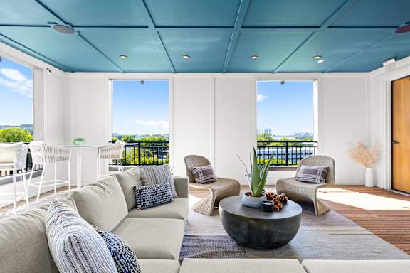 A modern living room with a large sofa and a view of the ocean.