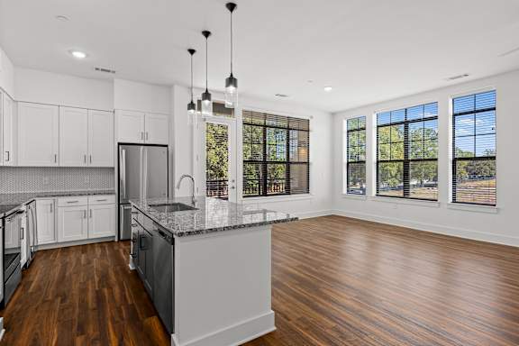 A modern kitchen with wooden floors and a large island.