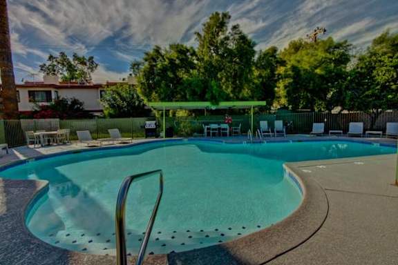 A small pool with a green canopy and a metal ladder.