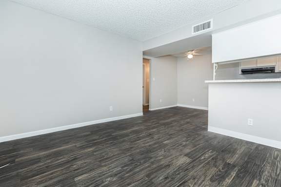 A room with a wooden floor and a white wall.
