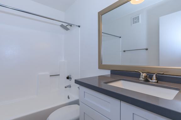 A white bathroom with a white tub and a white toilet.
