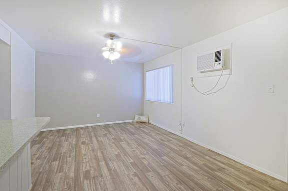 A room with a ceiling fan and a window with blinds.