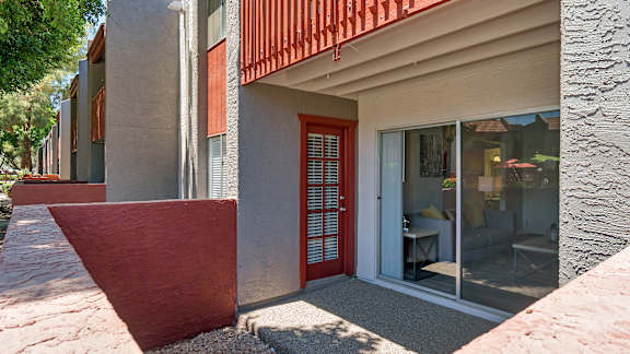A modern house with a red door and glass windows.