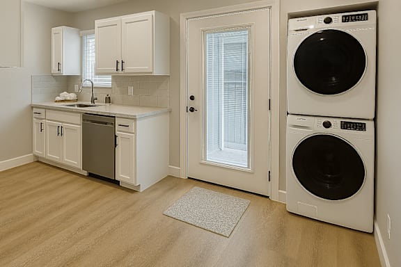 A white laundry room with a washer and dryer stacked on top of each other.