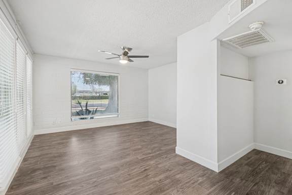 A room with a ceiling fan and a window overlooking a patio at Palm Villas Apartments, Scottsdale, 85257