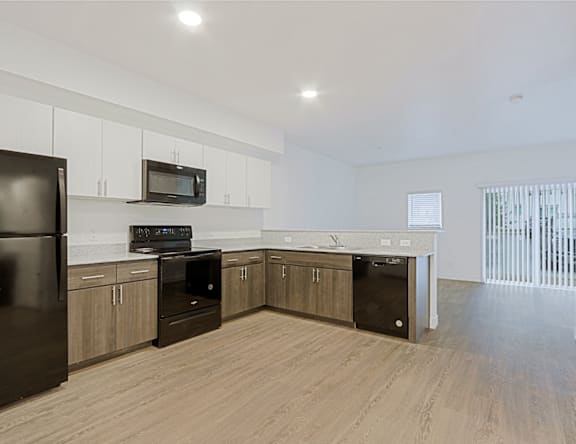 A kitchen with black appliances and wooden cabinets.