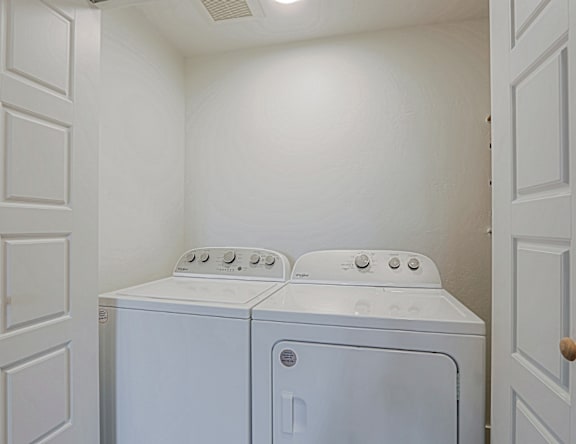 A small laundry room with a washer and dryer.