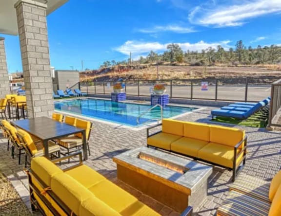 A pool area with yellow seating and a table.