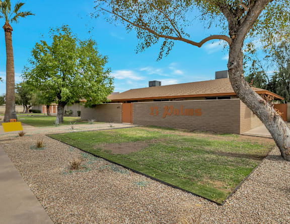 A building with a brown facade and a tree in front of it.