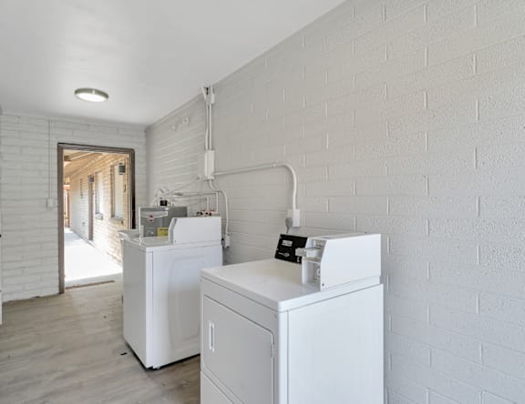A white washing machine and dryer in a laundry room.