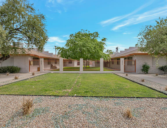 A modern house with a large front yard and a gravel path leading to the entrance.