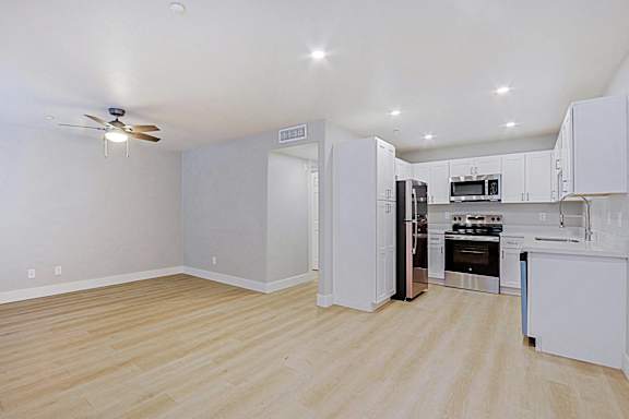 a renovated kitchen with white cabinets and stainless steel appliances
