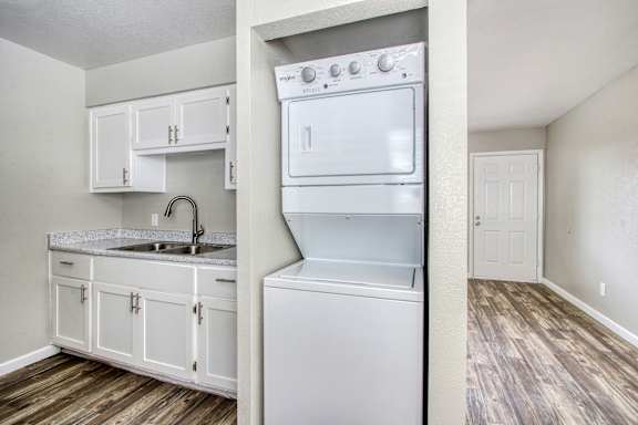 A white kitchen with a washer and dryer built in.