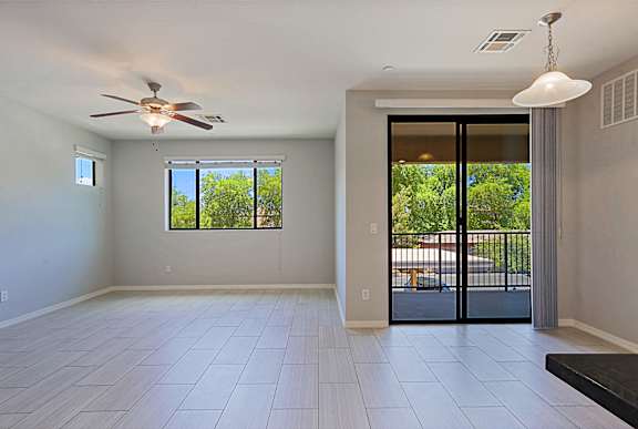 A spacious room with a ceiling fan and sliding glass doors.