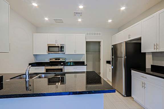 A modern kitchen with stainless steel appliances and white cabinets.