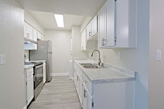 A kitchen with white appliances and cabinets.