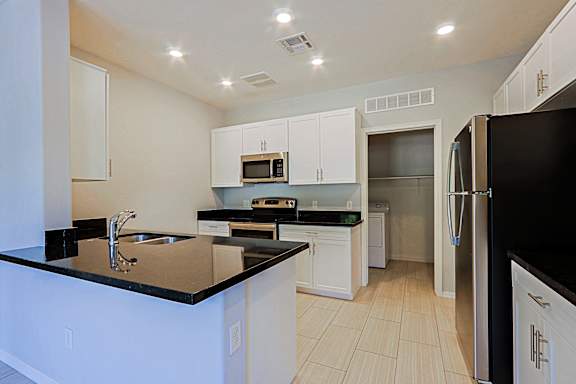 A kitchen with black countertops and white cabinets.