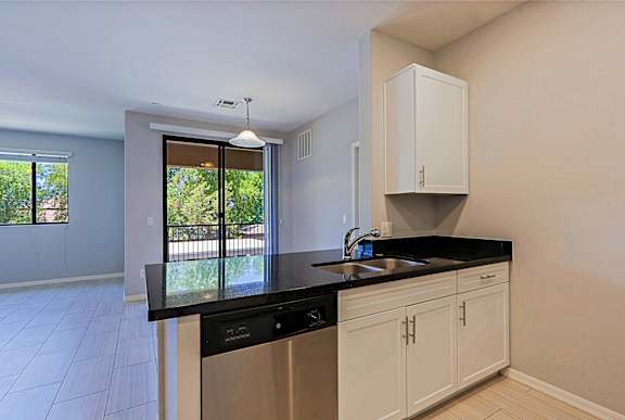 A kitchen with black countertops and white cabinets.