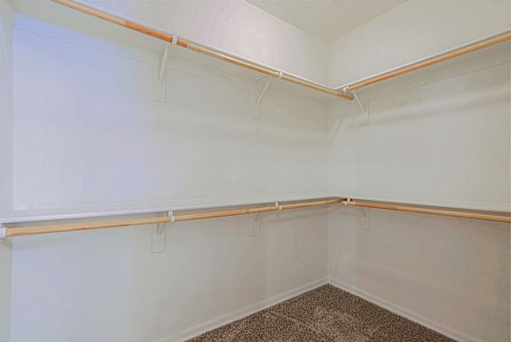 Empty room with white walls and a brown carpet.