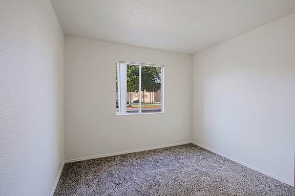 A room with a window and carpeted floor.