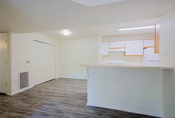 A white kitchen with wood floors and a white island.