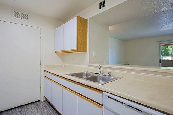 A kitchen with white cabinets and a wooden accent.