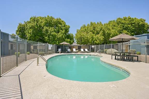 A large outdoor swimming pool surrounded by a fence.