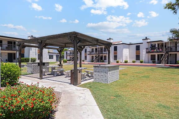 A building with a balcony and a pergola in front of it.