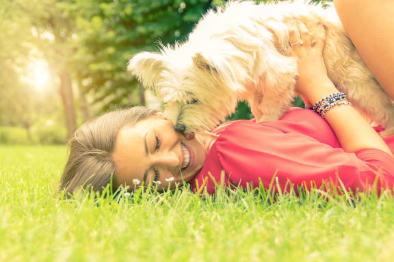 a woman laying in the grass with her dog