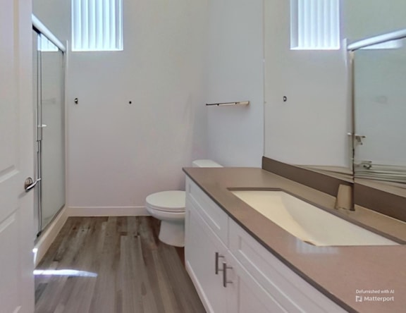 A bathroom with a toilet, sink, and mirror.