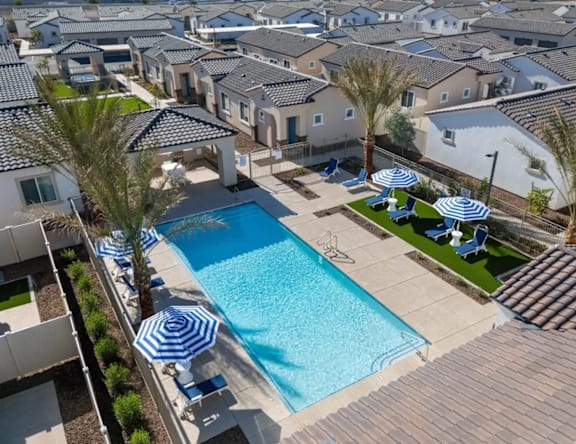 A swimming pool surrounded by a tiled roof and palm trees.