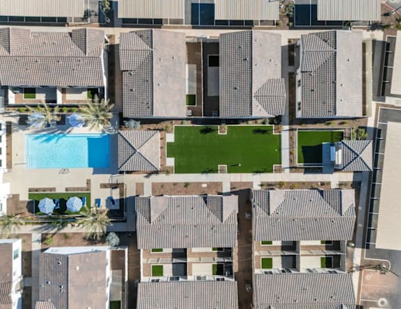 A large building complex with a pool and palm trees.