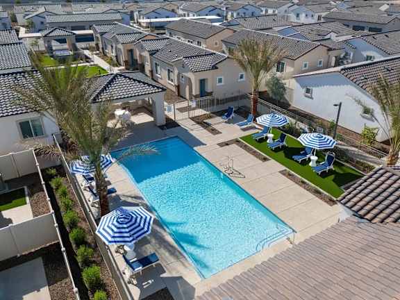 A swimming pool surrounded by blue and white striped umbrellas.