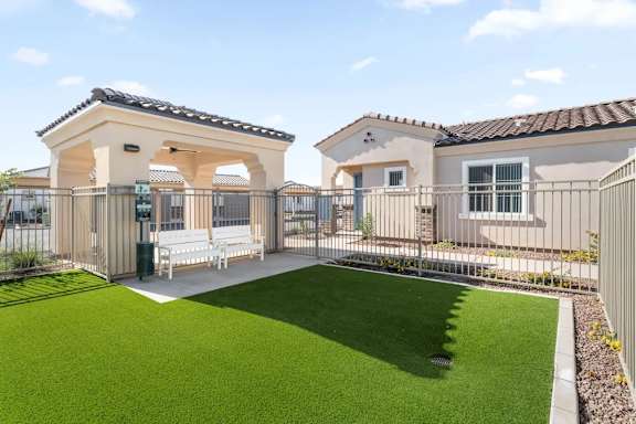 A house with a white fence and a green lawn.