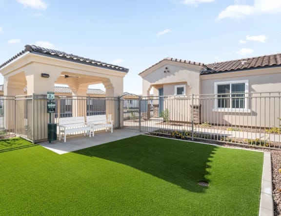 A house with a white fence and a green lawn.