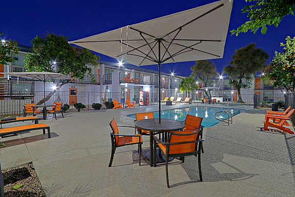 A patio with a table and chairs and an umbrella.