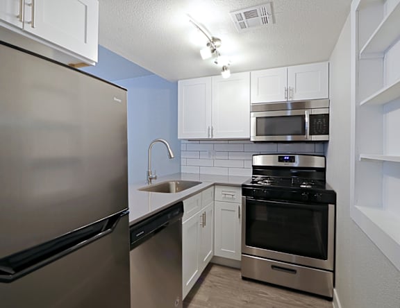 A kitchen with a stainless steel refrigerator and oven.