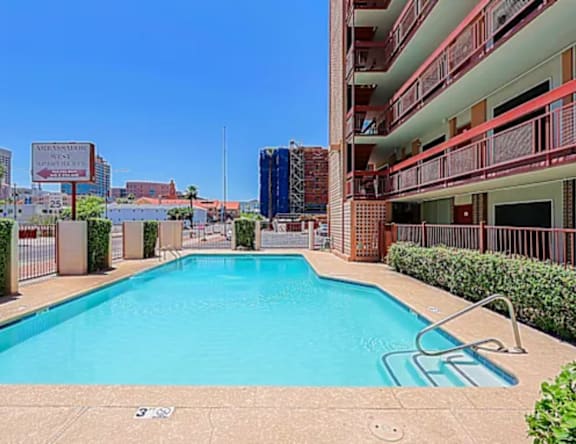 A swimming pool in front of a building with a sign that says "Our Residence".