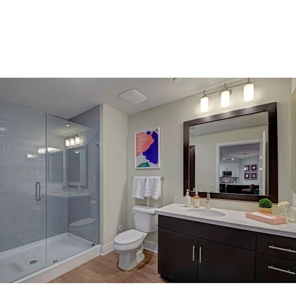 A bathroom with a toilet, sink, and shower.