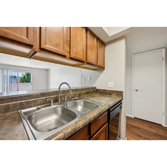 A kitchen with a sink and brown cabinets.
